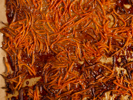 Carottes râpées enrobées de sirop sucré caramélisées sur du papier parchemin